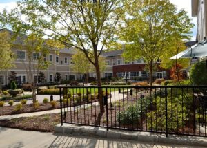 Exterior View of Sterling Estates Building with Trees and Fence in View