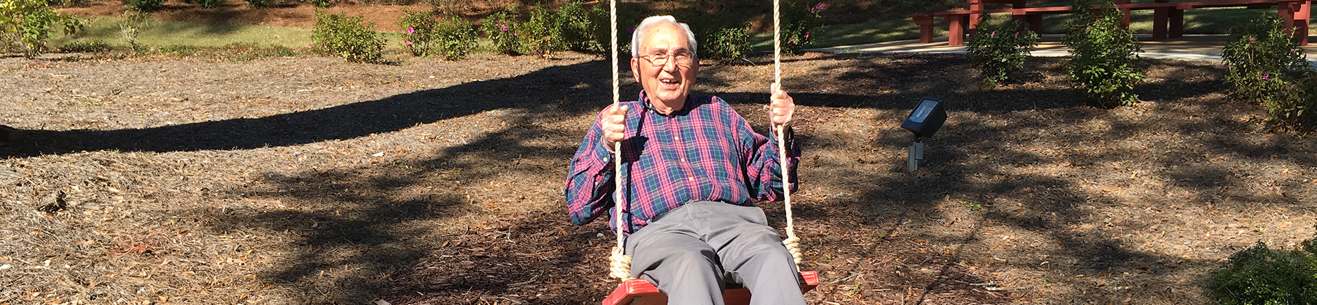 Senior man smiling on a swing