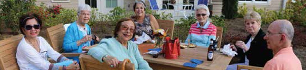 Smiling senior living residents sitting at a table