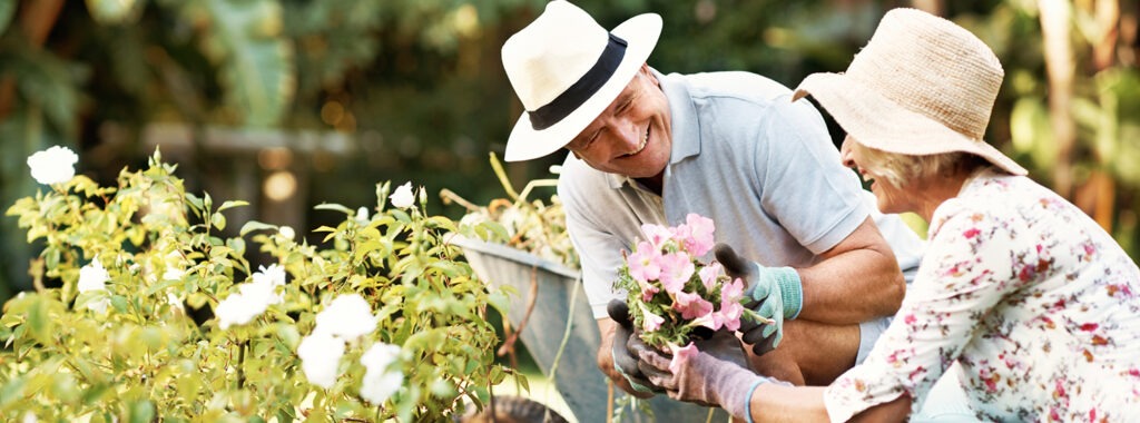 Senior Couple Smiling While Gardening at Sterling Estates