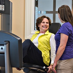 Senior doing strength training exercise with trainer