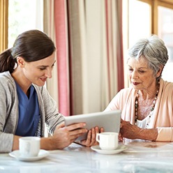 Senior woman consulting with woman about programs
